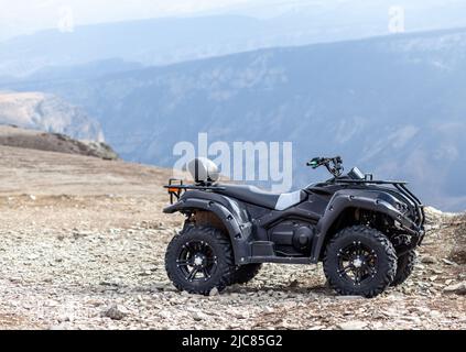 Quad ATV di fronte al paesaggio montano. Sci e attività ricreative all'aperto in montagna. Foto Stock