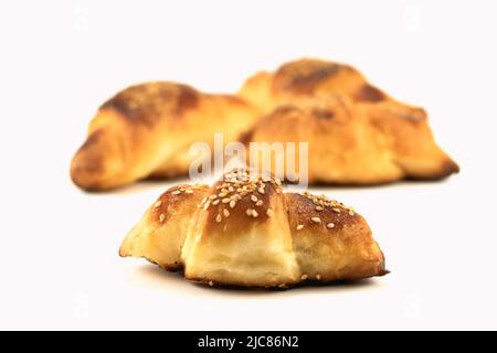 Panini fatti in casa con sesamo ripieni di formaggio isolato su uno sfondo luminoso. Messa a fuoco selettiva. Primo piano. Foto Stock