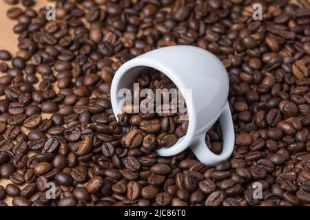 Caffè espresso in chicchi arrosto e una tazza bianca Foto Stock