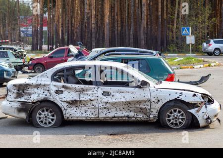 Un'auto distrutta da un razzo che esplose nelle vicinanze. Cimitero automobilistico Irpensky. Conseguenze dell'invasione dell'esercito russo a Ukra Foto Stock