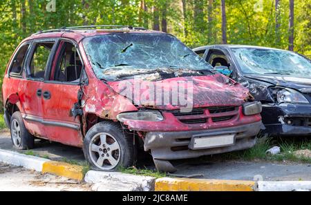 Un'auto distrutta da un razzo che esplose nelle vicinanze. Cimitero automobilistico Irpensky. Conseguenze dell'invasione dell'esercito russo a Ukra Foto Stock