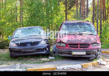 Un'auto distrutta da un razzo che esplose nelle vicinanze. Cimitero automobilistico Irpensky. Conseguenze dell'invasione dell'esercito russo a Ukra Foto Stock