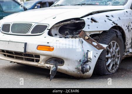 Un'auto distrutta da un razzo che esplose nelle vicinanze. Cimitero automobilistico Irpensky. Conseguenze dell'invasione dell'esercito russo a Ukra Foto Stock