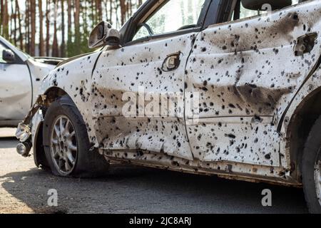 Un'auto distrutta da un razzo che esplose nelle vicinanze. Cimitero automobilistico Irpensky. Conseguenze dell'invasione dell'esercito russo a Ukra Foto Stock