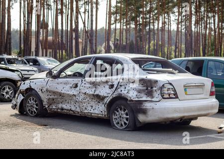 Un'auto distrutta da un razzo che esplose nelle vicinanze. Cimitero automobilistico Irpensky. Conseguenze dell'invasione dell'esercito russo a Ukra Foto Stock