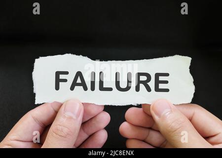 Gestire e accettare il concetto di errore. Carta per la tenuta della mano con scritta word failure su sfondo nero. Foto Stock