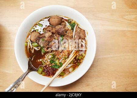 Spaghetti istantanei con manzo brasato in un recipiente Foto Stock
