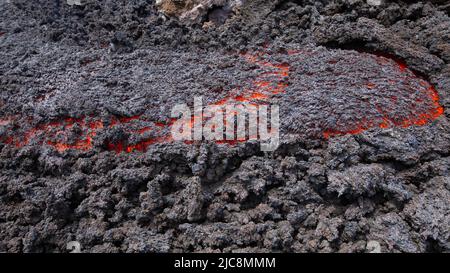 Flusso di lava incandescente sul vulcano Etna in Sicilia nella Valle del Bove con canale di fumo e flusso di lava Foto Stock