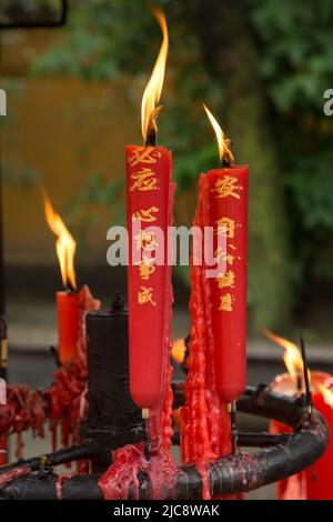 Candele votive con personaggi cinesi che bruciano nella Sala Arhat del Tempio Giardino Ovest, Suzhou, Cina. Foto Stock