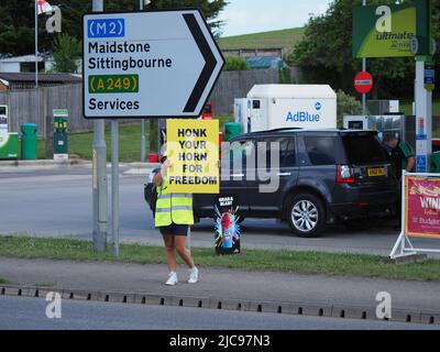 Queenborough, Kent, Regno Unito. 11th giugno 2022. Un gruppo di manifestanti è apparso al di fuori della stazione di servizio di Queenborough Corner questo pomeriggio, protestando contro i vaccini covidi dei bambini. Il gruppo è conosciuto come "Stand in the Park" - filiale di Sittingbourne. 'Uno stand nel Parco' è un raduno / campagna in tutto il mondo secondo un opuscolo fornito da uno dei manifestanti. Credit: James Bell/Alamy Live News Foto Stock