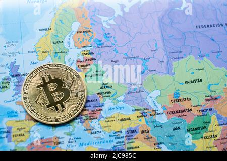 Una moneta in moneta da Bitcoin su una mappa politica Europa e Asia, vicino all'Ucraina, l'uso della criptovaluta, gli aiuti alla guerra Ucraina, il potere economico Foto Stock