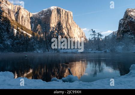 Impressione delle montagne che circondano la Valle di Yosemite, durante l'ora d'oro, che si riflettono nel fiume Merced. Foto Stock