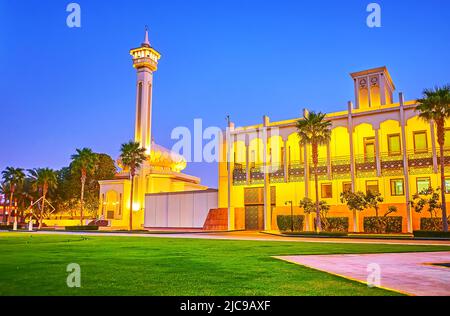 Il moderno e bello edificio di Ruler's Court e la sua moschea con un alto e sottile minareto con illuminazione dorata, Dubai, Emirati Arabi Uniti Foto Stock