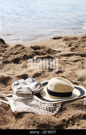 Accessori da spiaggia: Borsa ecologica in mesh, cappello di paglia, sandali Foto Stock