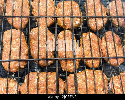 polpette sulla griglia. polpette crude cotte sul barbecue Foto Stock