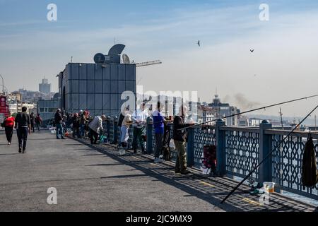 Persone che pescano dal ponte Galata attraversando il canale del Corno d'Oro. Istanbul, Türkiye. Foto Stock