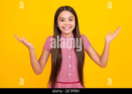 Faccia eccitata. Ritratto di ragazza gioiosa con le mani sollevate. Adolescente caucasico urlando isolato su giallo. Bambino felice esclamando con gioia e. Foto Stock