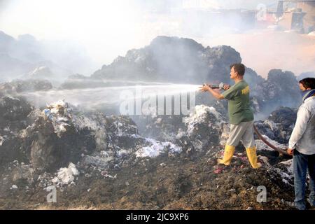 Vista della sede dopo l'eruzione del fuoco nell'edificio di una fabbrica di cotone a causa di motivi sconosciuti dopo un incendio scoppiato come i funzionari dei vigili del fuoco sono occupati nel fuoco estinguente, situato nell'area DEL SITO a Hyderabad il Sabato 11 giugno 2022. Foto Stock