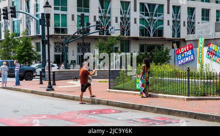 ASHEVILLE, NC, USA-5 GIUGNO 2022: Uomo che scatta la foto della donna a Pack Square Park nel centro città. Foto Stock