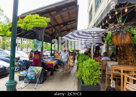 ASHEVILLE, NC, USA-5 GIUGNO 2022: Venditori sul marciapiede al Grove Arcade. Molte persone che si trovano a fare shopping e a passare. Foto Stock