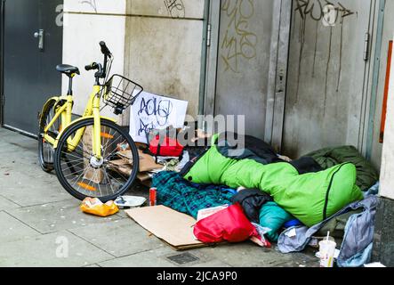 Uomo senza tetto con bicicletta e sacco a pelo addormentato nella porta a South Kennsington London UK 1-10-2018 Foto Stock