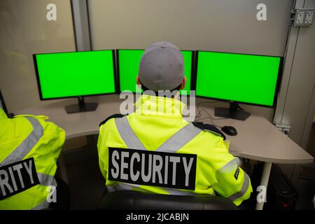 Il team addetto alla sicurezza guarda i monitor di sorveglianza TVCC. Foto Stock