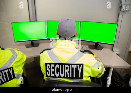 Il team addetto alla sicurezza guarda i monitor di sorveglianza TVCC. Foto Stock