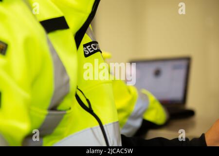 Il team addetto alla sicurezza guarda i monitor di sorveglianza TVCC. Foto Stock
