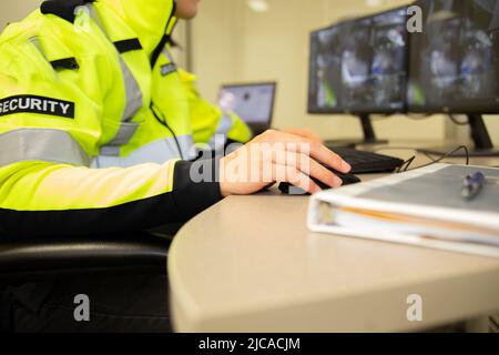 Il team addetto alla sicurezza guarda i monitor di sorveglianza TVCC. Foto Stock