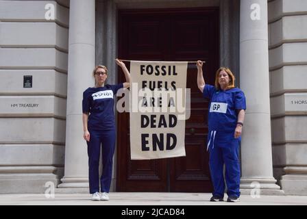 Londra, Inghilterra, Regno Unito. 11th giugno 2022. I manifestanti detengono una bandiera anti-combustibili fossili fuori dal Tesoro. Estinzione medici, infermieri e altri professionisti della Rebellion si sono riuniti a Westminster per chiedere la fine degli investimenti nei combustibili fossili. (Credit Image: © Vuk Valcic/ZUMA Press Wire) Foto Stock