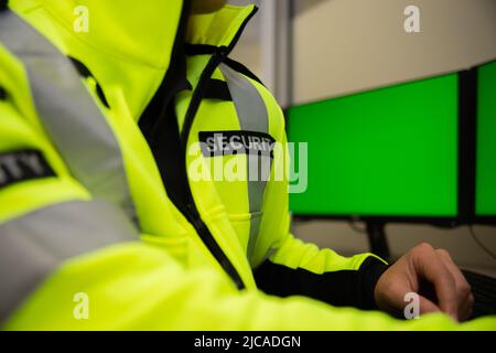 Il team addetto alla sicurezza guarda i monitor di sorveglianza TVCC. Foto Stock