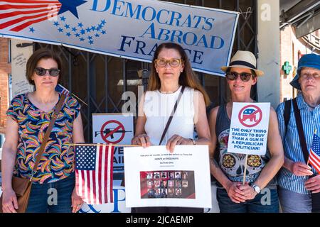 Gruppo di donne americane, di fronte a una bandiera, Democratici all'estero Francia. Una delle donne ha un poster con immagini delle diverse vittime, agli occhi del mondo, la morte dei bambini in Texas STA ONORANDO e SQUALIFICANDO gli Stati Uniti. Alessandria Ocaso-Cortez. Il Partito democratico si raduna all'estero per onorare le vittime dell'uccisione della Scuola elementare Robb a Uvalde, Texas, il 24 maggio 2022. Francia, Toulouse le 11 Juin 2022. Foto di Patricia Huchot-Boissier/ABACAPRESS.COM Foto Stock