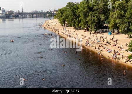 Kiev, Ucraina. 11th giugno 2022. Gli ucraini sono visti fare il bagno nel fiume Dnipro alla spiaggia pubblica in una giornata calda di sole in una città vecchia di Kyiv, Ucraina il 11 giugno 2022. Mentre la Federazione russa ha invaso l'Ucraina 3 mesi e mezzo fa, continuano feroci combattimenti nell'est del paese. La capitale, Kiev rimane in relativa sicurezza e la popolazione rivendica lo spazio pubblico e apre la strada alla normalizzazione. (Foto di Dominika Zarzycka/Sipa USA) Credit: Sipa USA/Alamy Live News Foto Stock