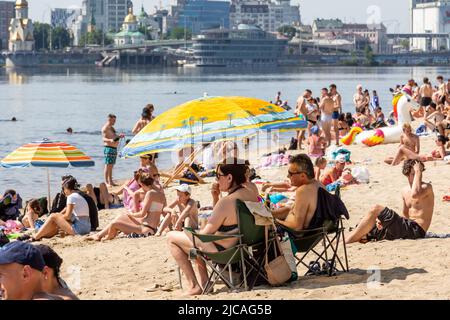 Kiev, Ucraina. 11th giugno 2022. Gli ucraini sono visti fare il bagno nel fiume Dnipro alla spiaggia pubblica in una giornata calda di sole in una città vecchia di Kyiv, Ucraina il 11 giugno 2022. Mentre la Federazione russa ha invaso l'Ucraina 3 mesi e mezzo fa, continuano feroci combattimenti nell'est del paese. La capitale, Kiev rimane in relativa sicurezza e la popolazione rivendica lo spazio pubblico e apre la strada alla normalizzazione. (Foto di Dominika Zarzycka/Sipa USA) Credit: Sipa USA/Alamy Live News Foto Stock