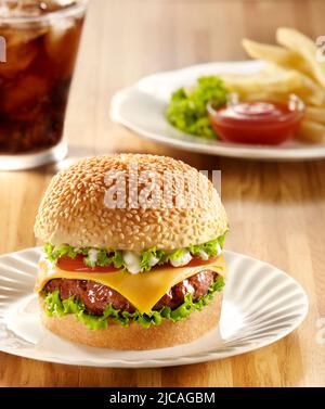 Pacchetto di hamburger di manzo e formaggio servito con patatine fritte in salsa di peperoncino e bevanda fredda di cola Foto Stock