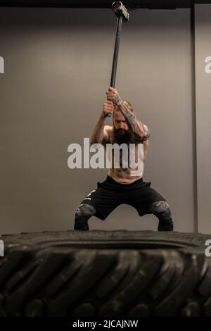 Mazza pneumatico ruota camion donna sostituire palestra martello giovane, per la concentrazione di attrezzature da maschio da allenamento muscolare, uomo adulto Foto Stock