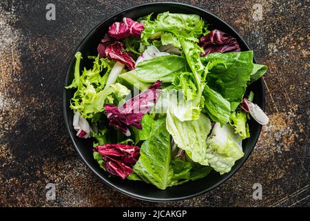 Fregio, romaina e lattuga di radicchio, su un vecchio sfondo rustico scuro, vista dall'alto Foto Stock