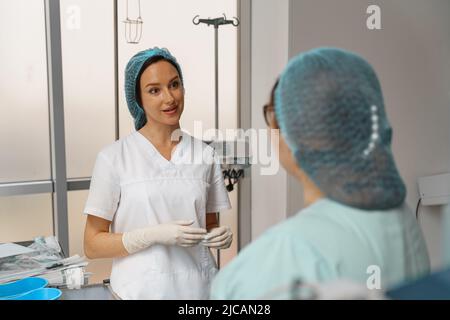 Due infermieri in uniforme che parlano in sala operatoria prima di un intervento chirurgico in clinica Foto Stock