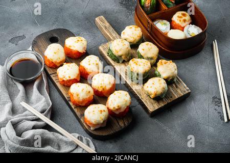 Panini di sushi giapponesi denominati EBI al forno con wasabi e pesce di salmone, su sfondo di pietra grigia Foto Stock