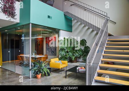 Lobby di moderno spazio ufficio con sala riunioni in vetro e scala Foto Stock