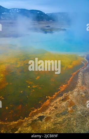 Misteriose piscine di Yellowstone con acque blu e gialle e vapore sulfureo Foto Stock