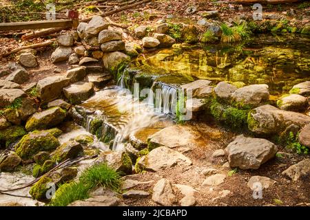 Primavera tranquilla con rocce di muschio e cascate Foto Stock