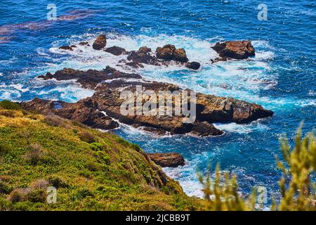 Le onde dell'oceano si infrangono in formazioni rocciose sulla costa occidentale Foto Stock