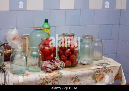 Concetto autunnale. Cibo conservato in vasetti di vetro su un asse di legno. Cibo marinato Foto Stock
