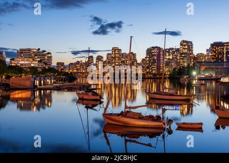 Notte della città urbana, skyline al crepuscolo di Vancouver. Barche sul False Creek. Edifici luci riflessione sul fiume acqua. British Columbia, Canada. Foto Stock