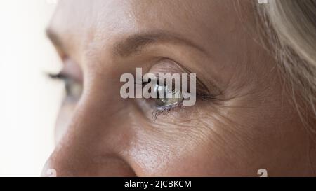 La donna più anziana guarda a distanza, ritagliata vista del volto Foto Stock