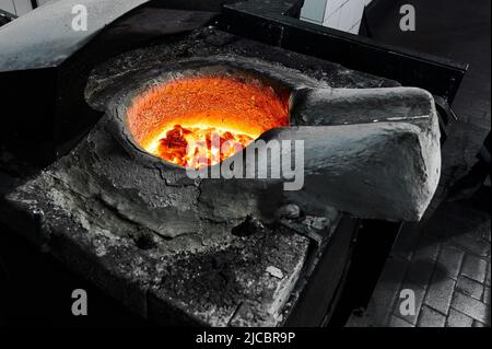 Metallo con strato di flussante in crogiolo di forno induttivo Foto Stock