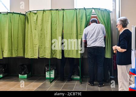 12 giugno 2022, Cours la Ville, Auvergne Rhone Alpes, Francia: Un uomo che entra in una cabina di voto. Il popolo francese è chiamato a votare per il primo turno delle elezioni legislative che eleggeranno i deputati che siederanno all'Assemblea nazionale. Qui, in un seggio di Cours-la-Ville la Domenica mattina. (Credit Image: © Adrien Fillon/ZUMA Press Wire) Foto Stock