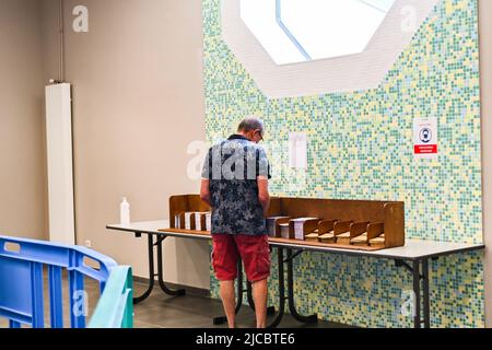 12 giugno 2022, Cours la Ville, Auvergne Rhone Alpes, Francia: Un uomo sceglie le schede di scrutinio. Il popolo francese è chiamato a votare per il primo turno delle elezioni legislative che eleggeranno i deputati che siederanno all'Assemblea nazionale. Qui, in un seggio di Cours-la-Ville la Domenica mattina. (Credit Image: © Adrien Fillon/ZUMA Press Wire) Foto Stock