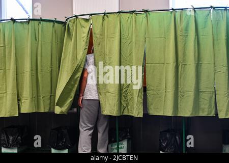 12 giugno 2022, Cours la Ville, Auvergne Rhone Alpes, Francia: Un uomo che entra in una cabina di voto. Il popolo francese è chiamato a votare per il primo turno delle elezioni legislative che eleggeranno i deputati che siederanno all'Assemblea nazionale. Qui, in un seggio di Cours-la-Ville la Domenica mattina. (Credit Image: © Adrien Fillon/ZUMA Press Wire) Foto Stock